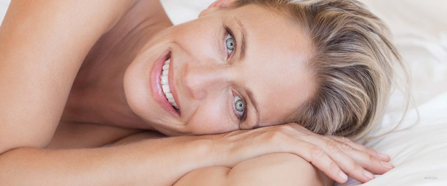 headshot of a woman laying in bed